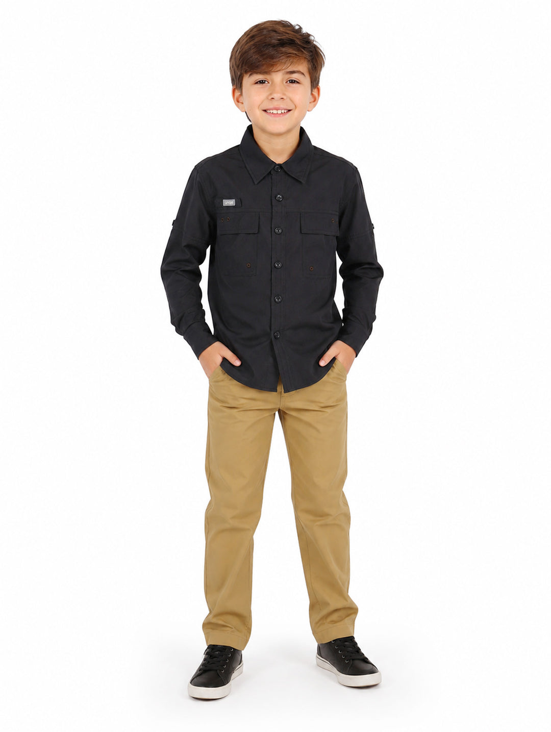 Niño vistiendo una camisa negra de manga larga estilo outdoor con botones y bolsillos frontales.