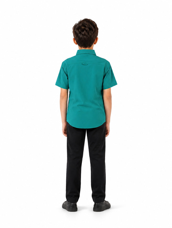 Niño vistiendo una camisa outdoor de color verde con manga corta y bolsillos frontales.