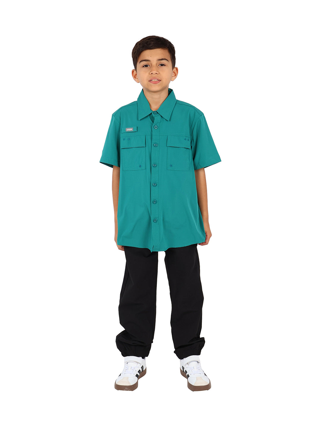 Niño vistiendo una camisa outdoor de color verde con manga corta y bolsillos frontales.