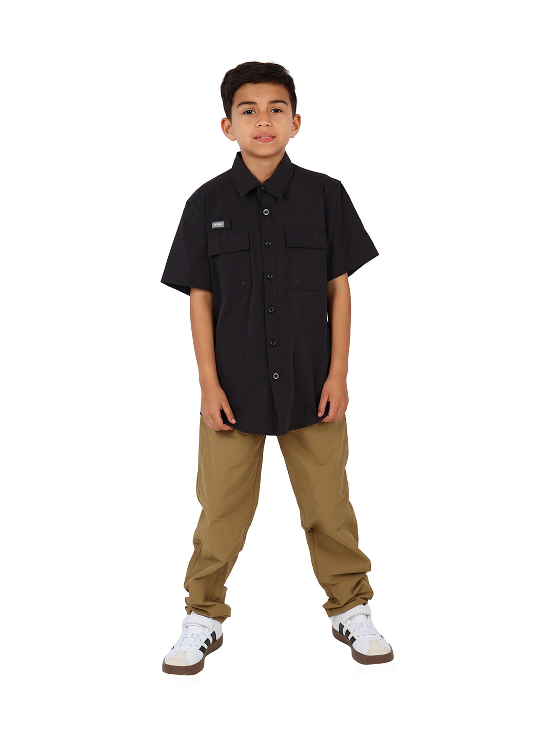 Niño vistiendo una camisa outdoor de color negro con manga corta y bolsillos frontales.