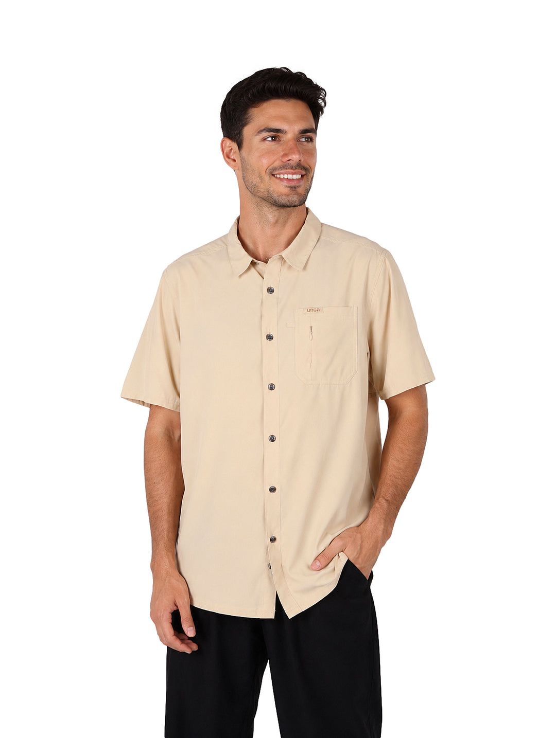 Hombre vistiendo una camisa outdoor de manga corta en color beige con cuello y un bolsillo frontal.