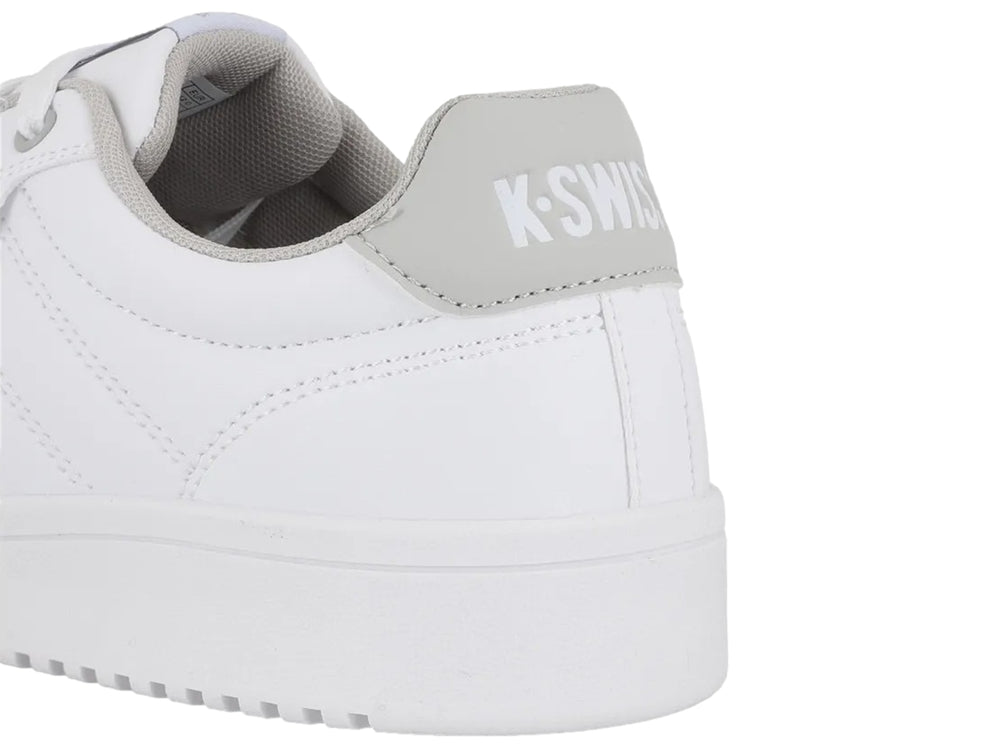 Tenis K-Swiss color blanco con detalle en gris en el talón y suela blanca.