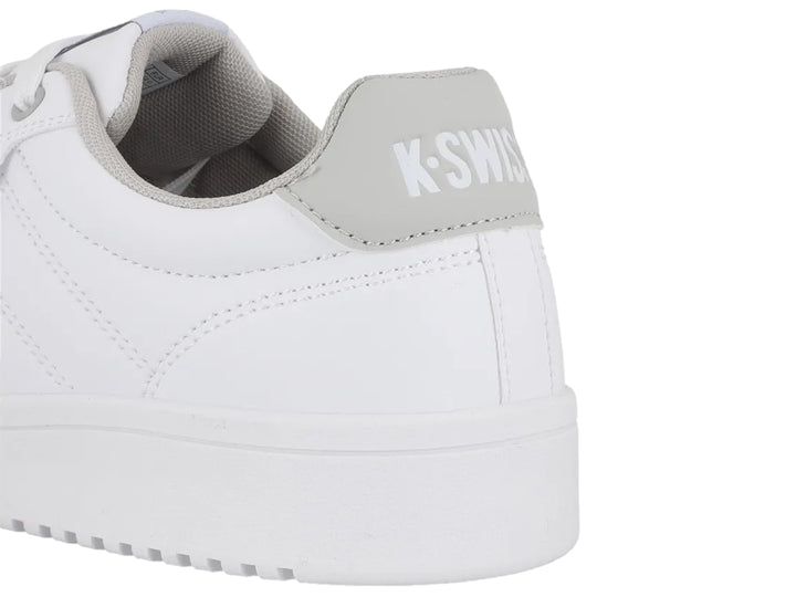 Tenis K-Swiss color blanco con detalle en gris en el talón y suela blanca.