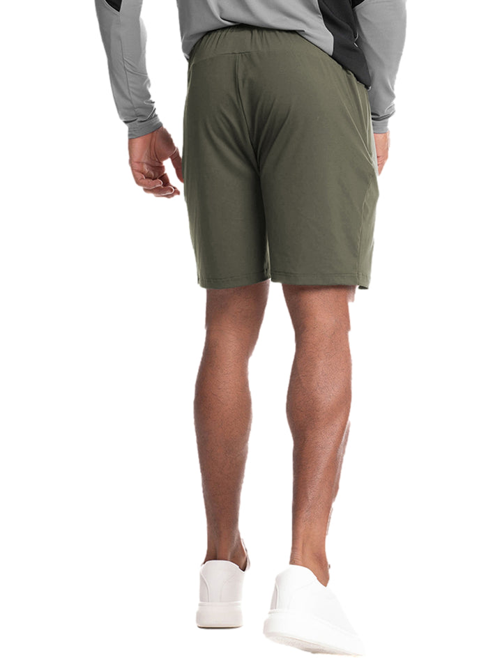 Hombre vistiendo un short deportivo de color olivo marca Everlast con tenis blancos.