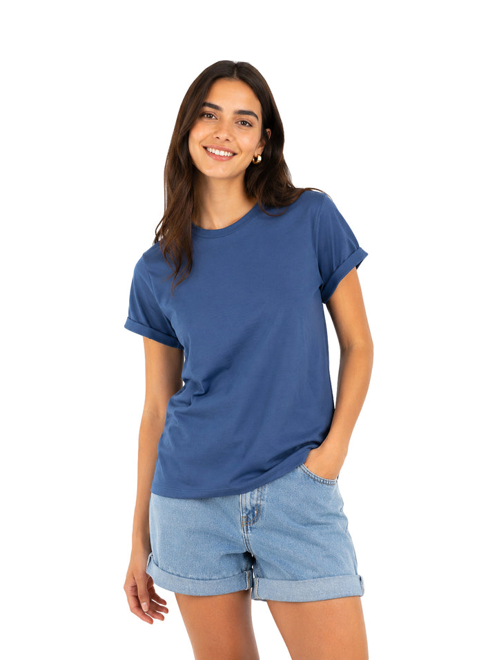 Mujer vistiendo una playera azul de manga corta y cuello redondo.