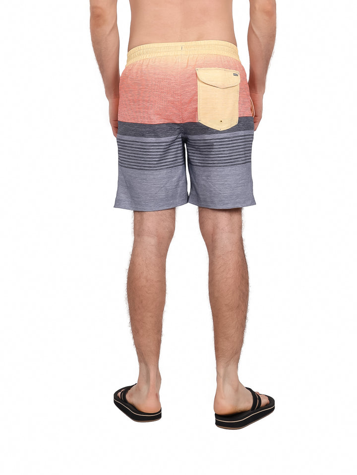 Hombre usando traje de baño Hurley color gris y naranja con rayas horizontales.