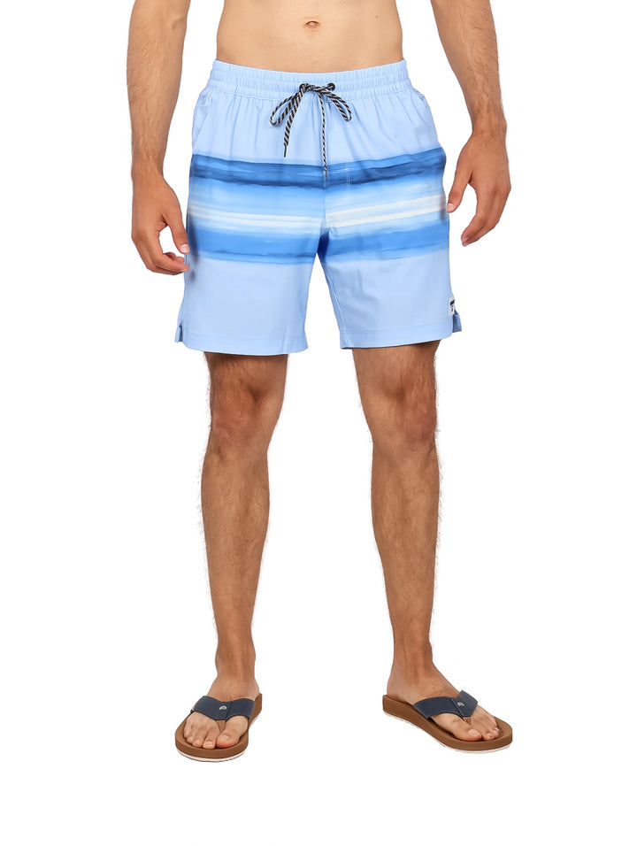 Hombre vistiendo traje de baño Hurley color azul místico con diseño de rayas horizontales.