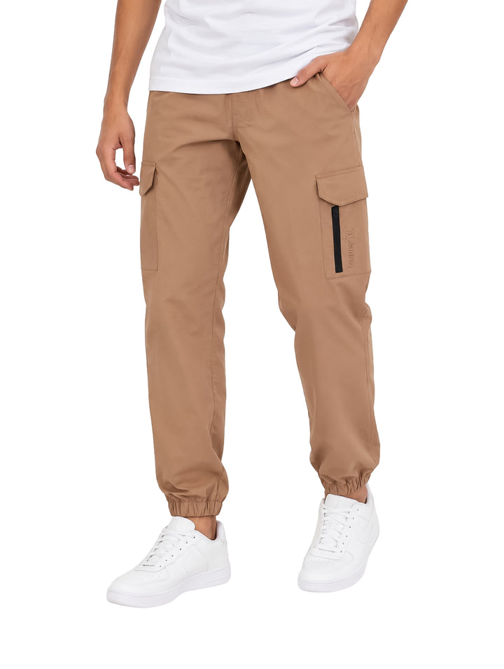 Hombre vistiendo pantalones jogger cargo Hurley color beige con bolsillos laterales y tobillos ajustados.