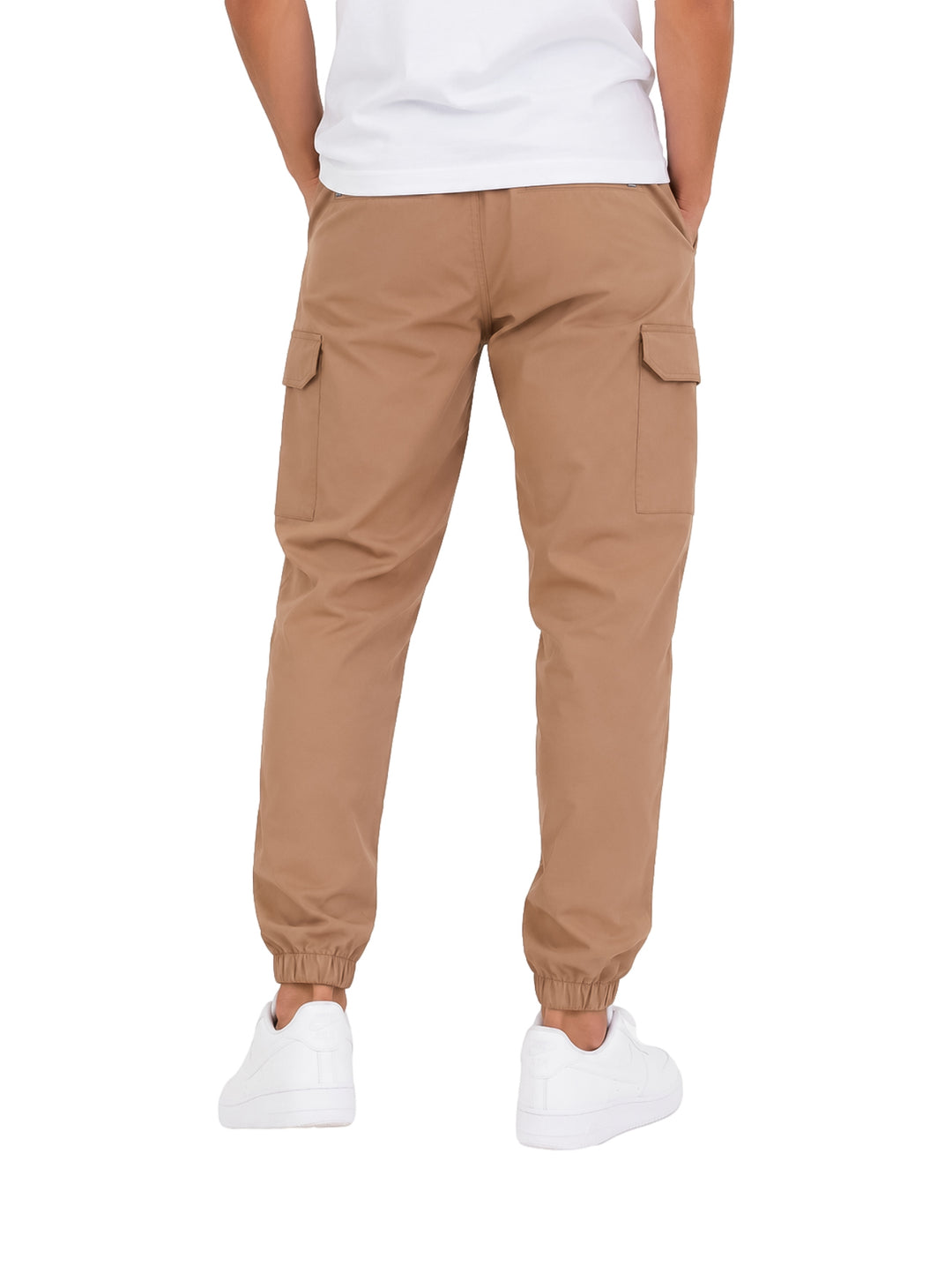 Hombre vistiendo pantalones jogger cargo Hurley color beige con bolsillos laterales y tobillos ajustados.