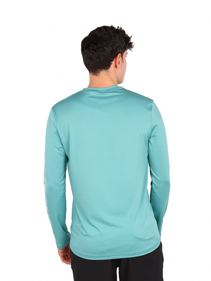 Hombre vistiendo playera de manga larga color verde jade de la marca Hurley.