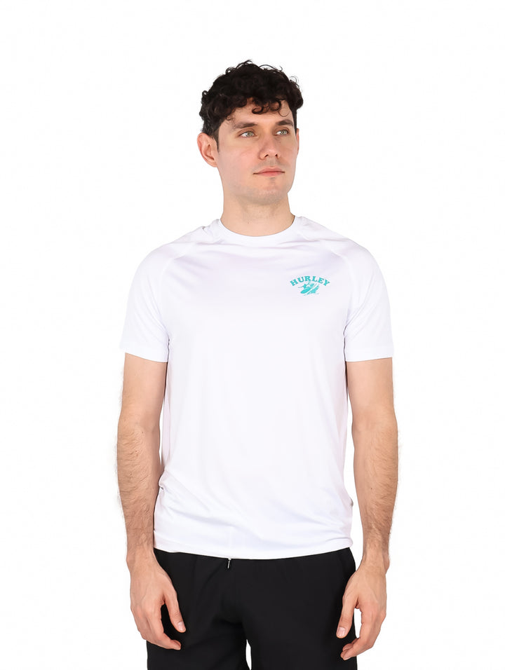 Hombre vistiendo playera blanca de manga corta marca Hurley con logotipo en el pecho.
