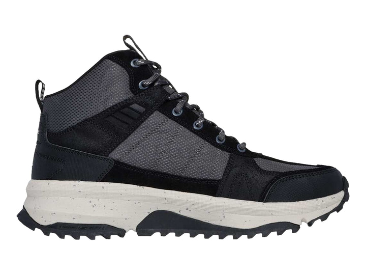 Bota deportiva Skechers en color negro y gris con suela blanca gruesa y tracción para actividades al aire libre.