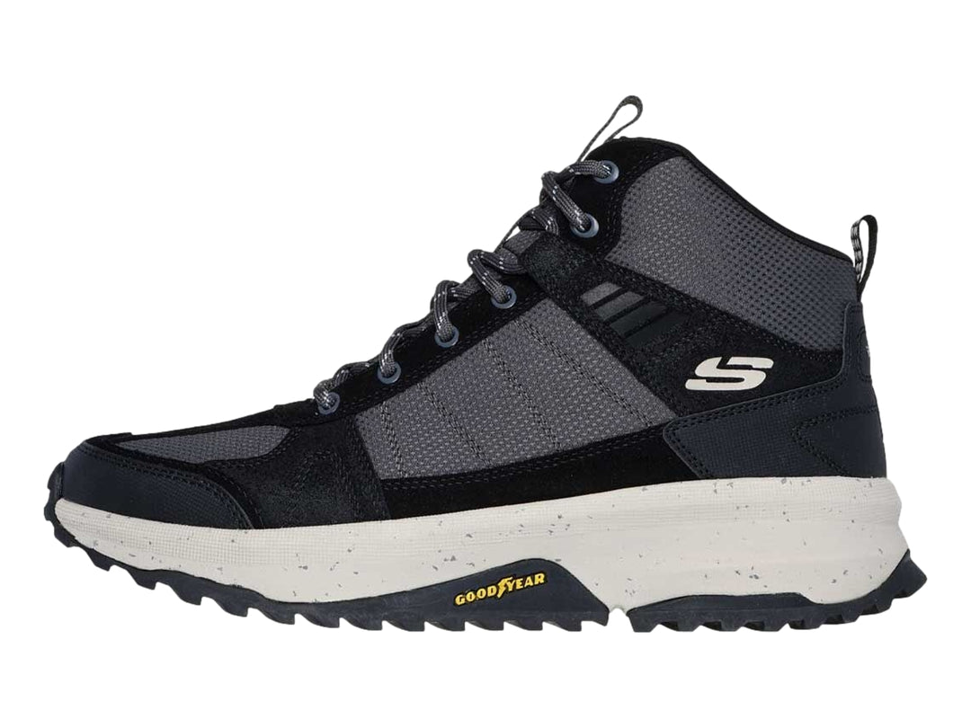 Bota deportiva Skechers en color negro y gris con suela blanca gruesa y tracción para actividades al aire libre.