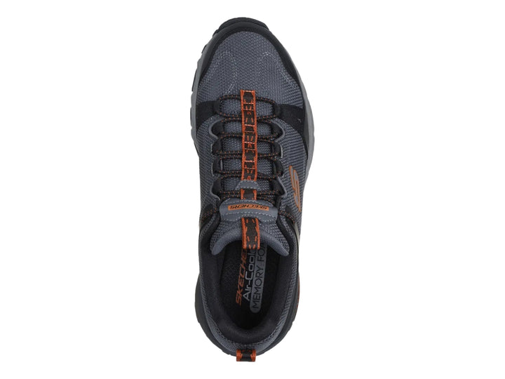 Tenis Skechers para hombre en color negro y gris, diseño robusto para actividades al aire libre con suela Goodyear.