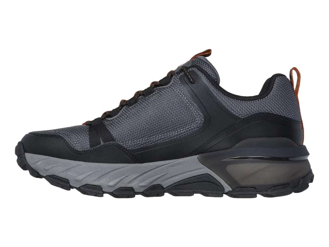 Tenis Skechers para hombre en color negro y gris, diseño robusto para actividades al aire libre con suela Goodyear.