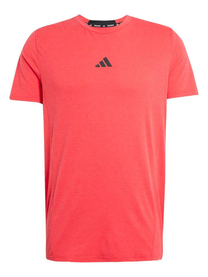 Hombre vistiendo una playera Adidas de color Pure Ruby con logo pequeño en el pecho y cuello redondo.