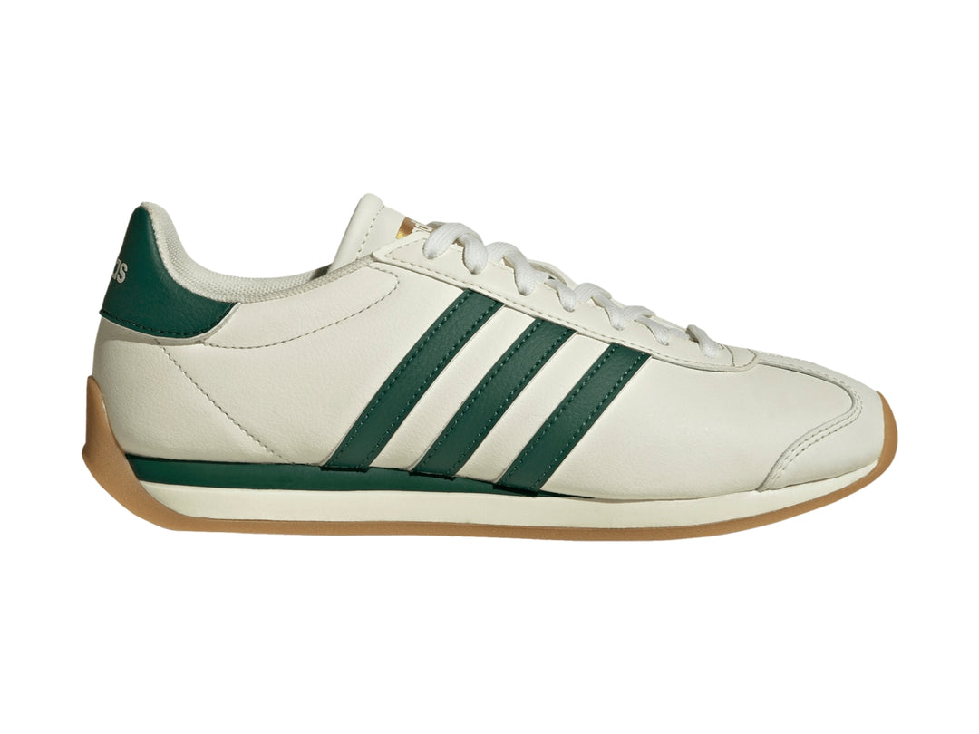 Tenis Adidas Runvista color blanco roto con tres franjas verdes y suela de goma marrón.