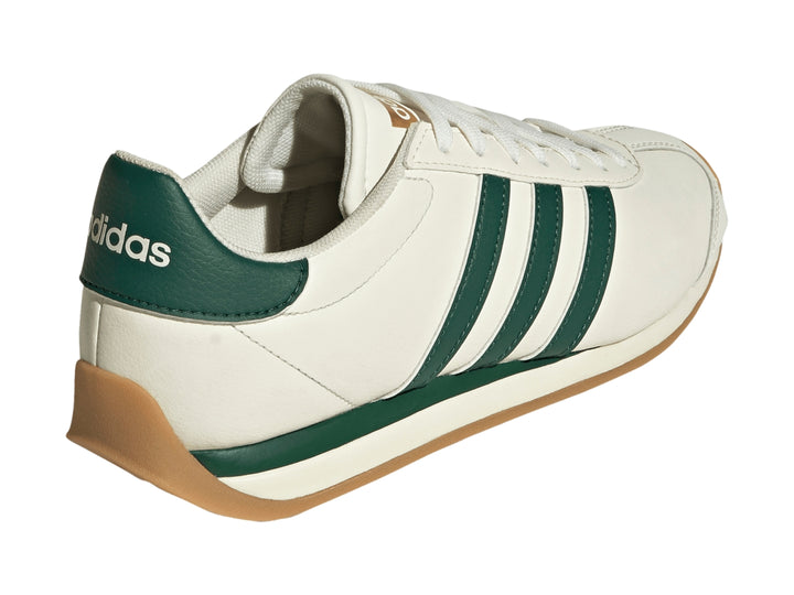 Tenis Adidas Runvista color blanco roto con tres franjas verdes y suela de goma marrón.