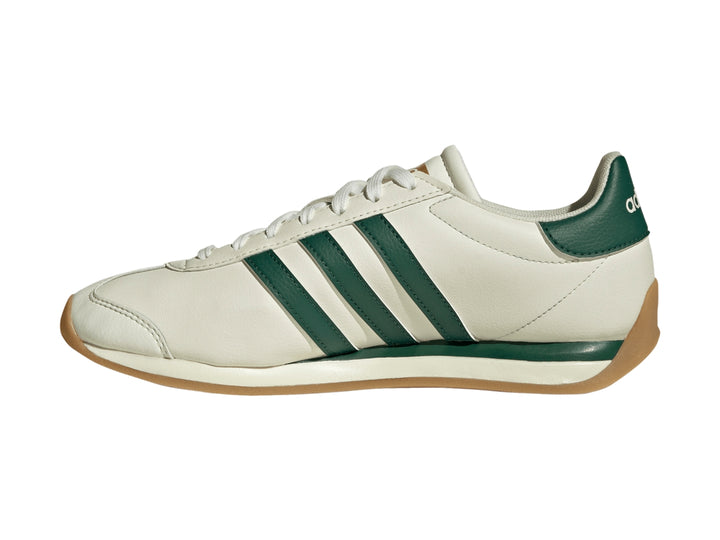 Tenis Adidas Runvista color blanco roto con tres franjas verdes y suela de goma marrón.