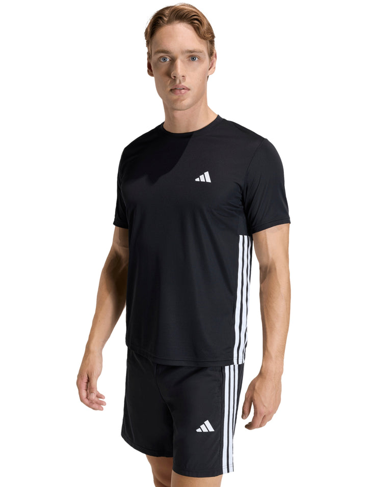 Hombre vistiendo conjunto deportivo Adidas negro con tres franjas blancas laterales y logotipo blanco.
