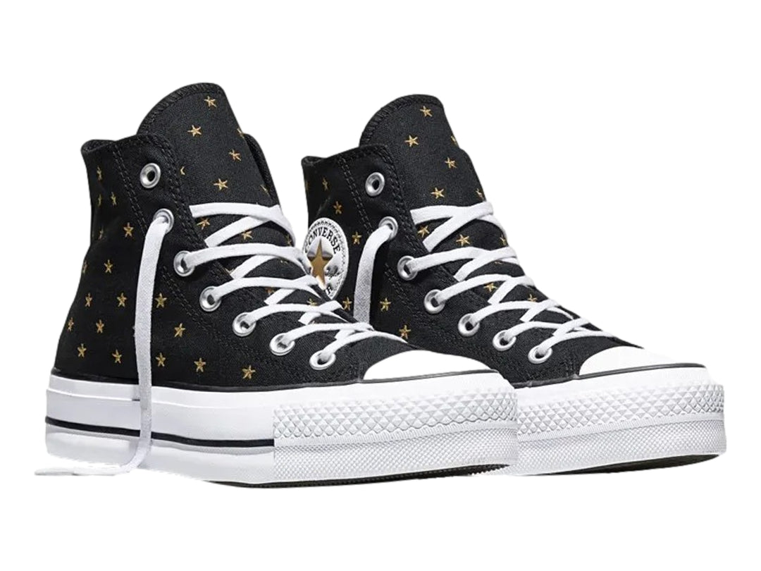 Tenis Converse negros de bota con plataforma blanca y estrellas doradas bordadas.