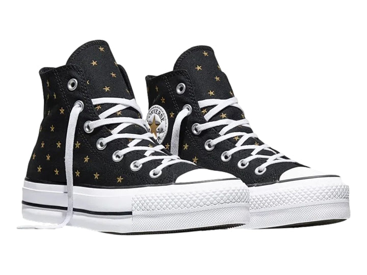 Tenis Converse negros de bota con plataforma blanca y estrellas doradas bordadas.