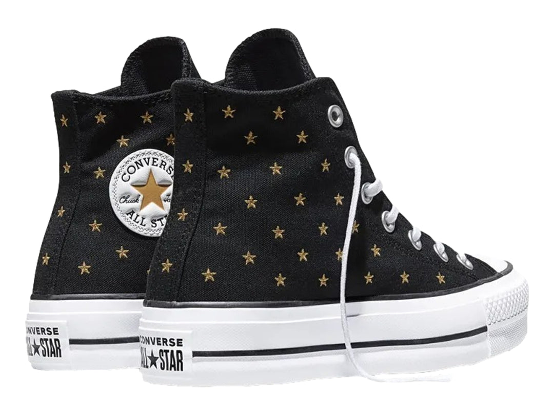 Tenis Converse negros de bota con plataforma blanca y estrellas doradas bordadas.