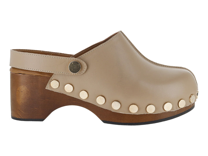 Zueco color sand de cuero con tacón de madera y detalles de remaches dorados laterales.