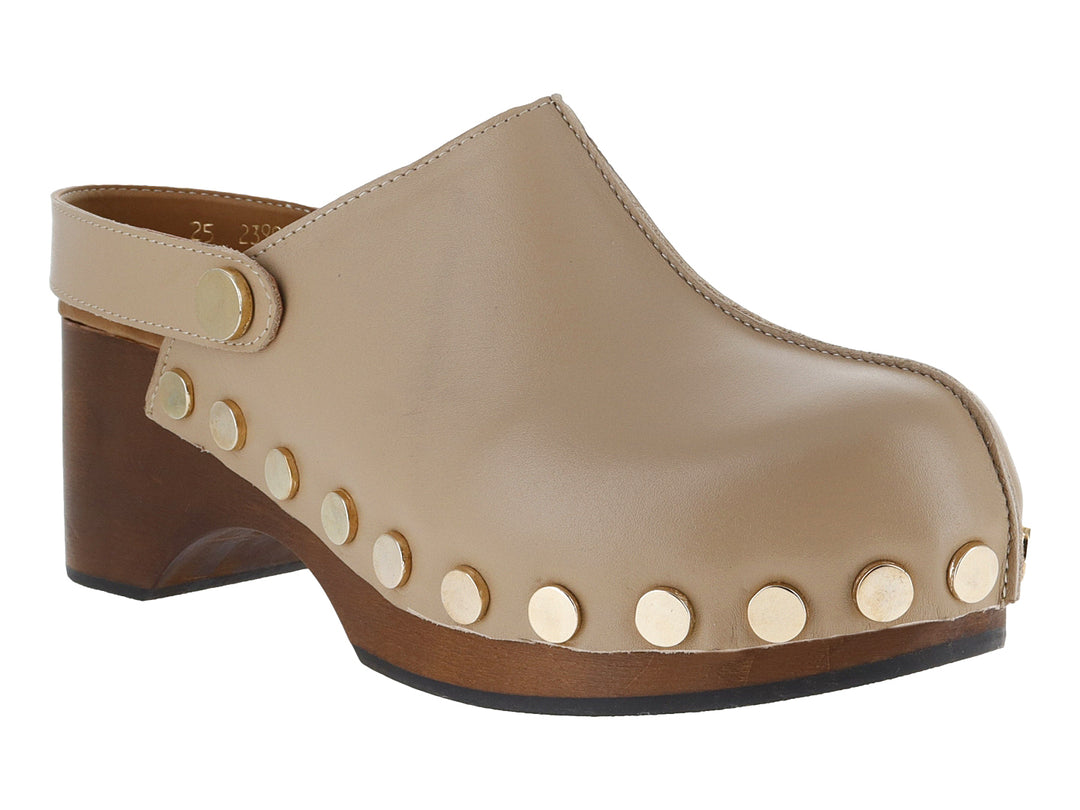 Zueco color sand de cuero con tacón de madera y detalles de remaches dorados laterales.