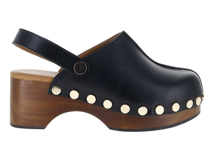 Zueco de cuero negro con plataforma de madera y detalles de remaches dorados laterales.