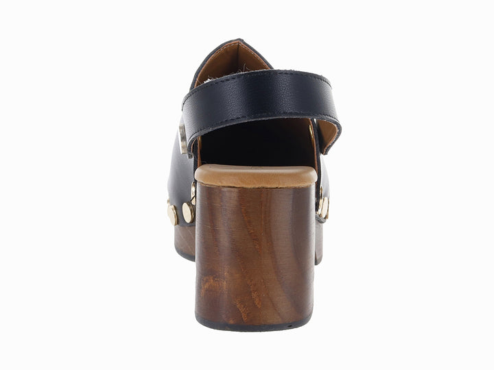 Zueco de cuero negro con plataforma de madera y detalles de remaches dorados laterales.