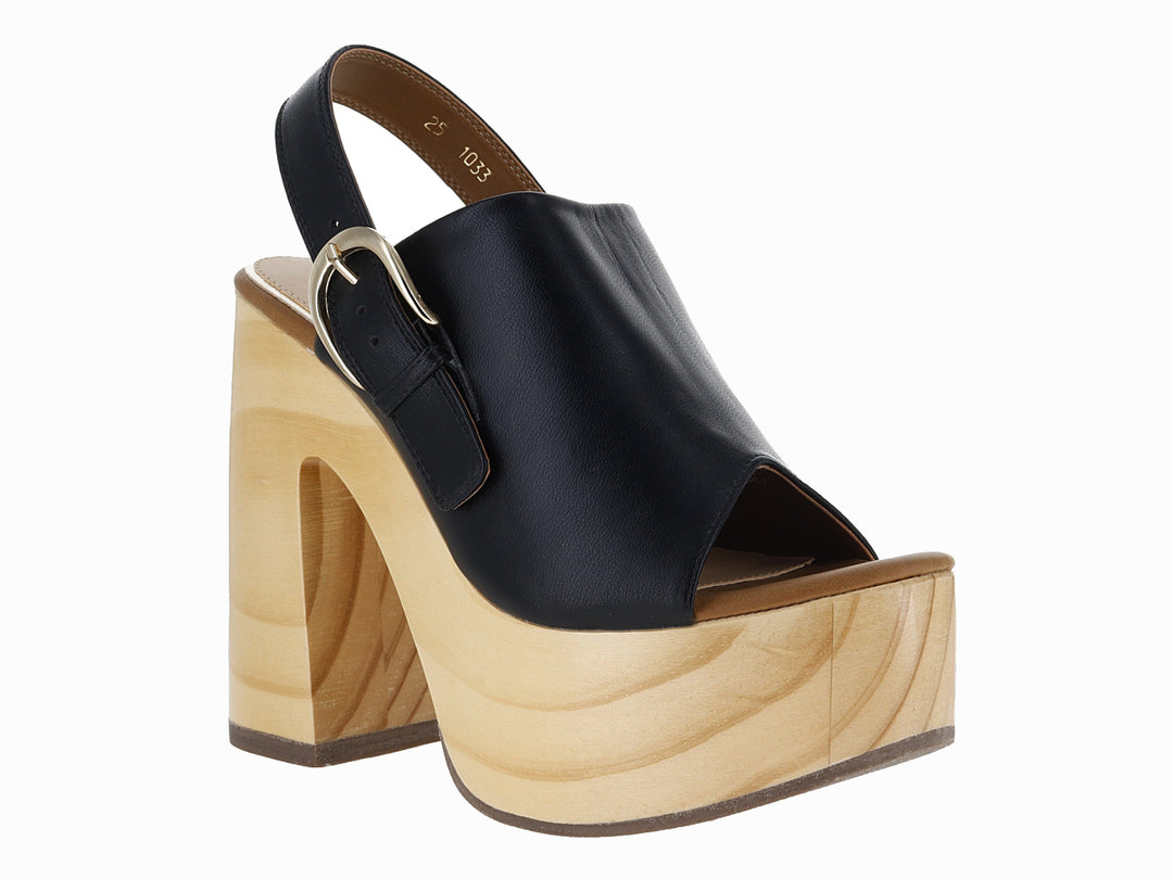 Sandalia de plataforma con tacón grueso color madera y correa de cuero negro con hebilla dorada.