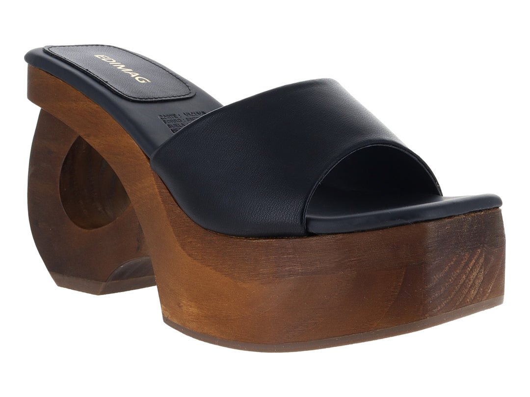 Sandalia de plataforma alta con banda de cuero negro y base de madera esculpida en color marrón.