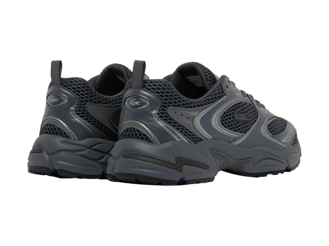 Tenis deportivos Lacoste color gris oscuro con diseño chunky y malla transpirable.