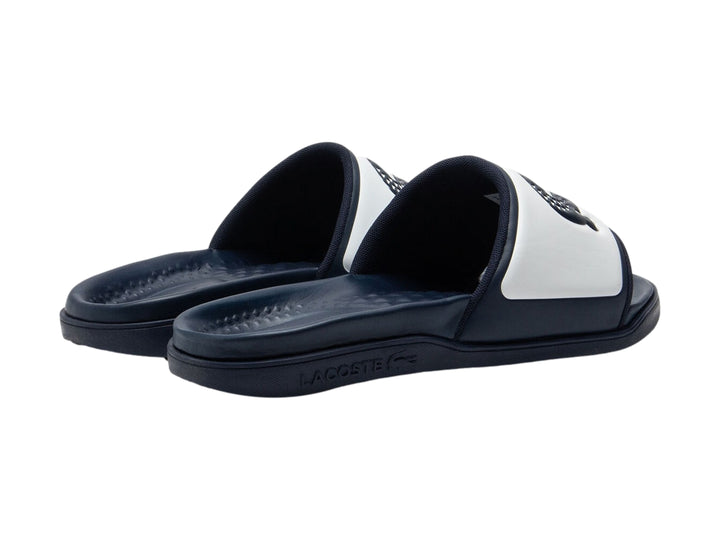 Sandalia Lacoste tipo slide en colores azul marino y blanco con logo frontal.