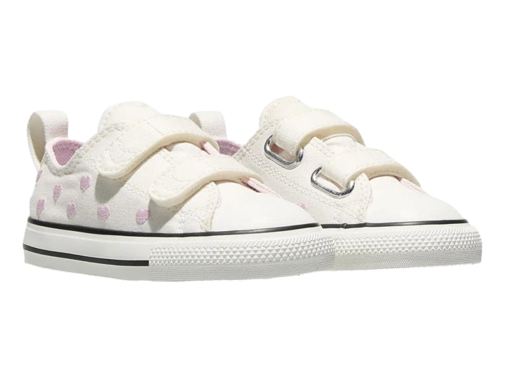 Tenis Converse color hueso con corazones rosas y cierres de velcro.
