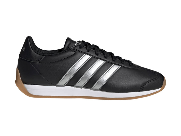 Tenis Adidas negros con tres franjas plateadas, entresuela blanca y suela de goma color café.