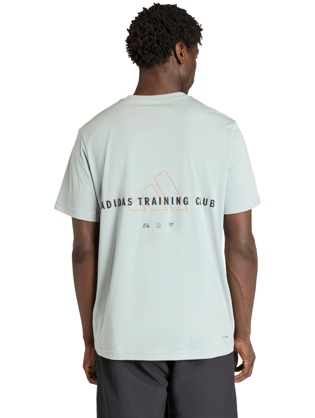 Hombre vistiendo camiseta deportiva Adidas color verde Wonder Sage con logo negro en el pecho.