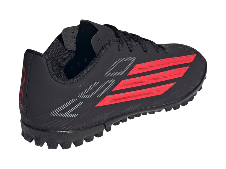 Calzado de fútbol Adidas F50 en color negro con franjas rojas y suela para césped sintético.