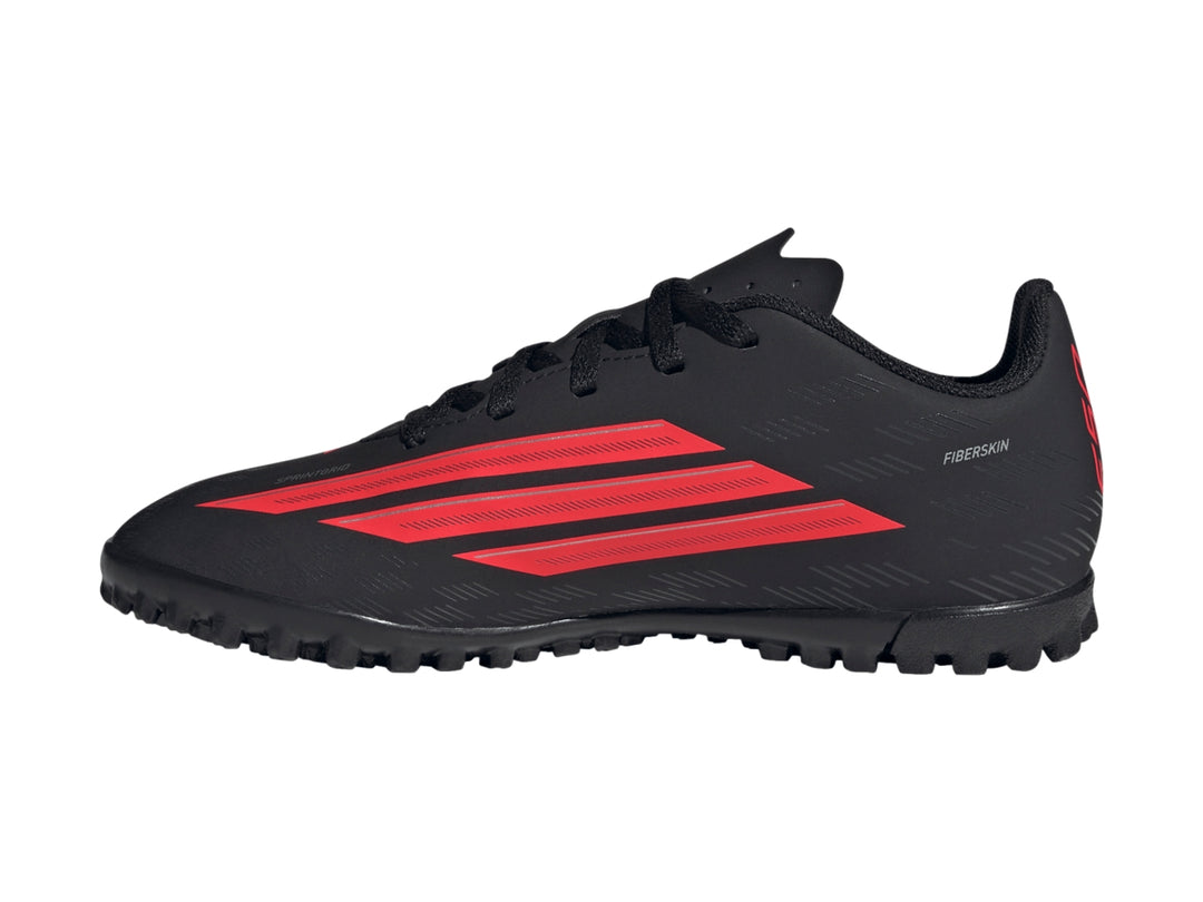 Calzado de fútbol Adidas F50 en color negro con franjas rojas y suela para césped sintético.