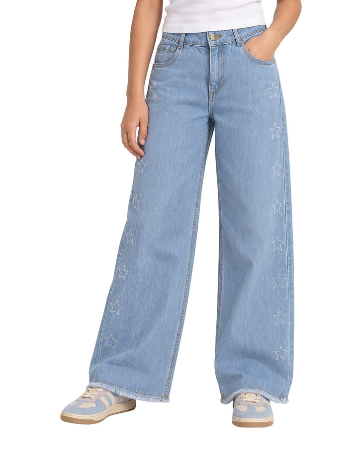 Pantalón vaquero azul claro de pierna ancha con bordados de estrellas blancas en los laterales para Niña.