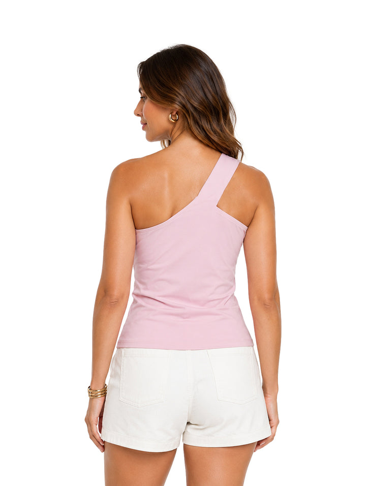 Mujer vistiendo blusa rosa asimétrica de un solo hombro con detalle de estrella dorada y shorts blancos.