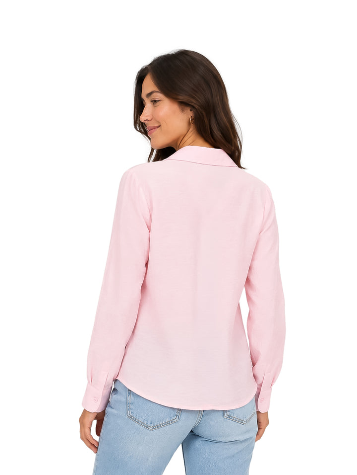 Mujer vistiendo una camisa rosa claro de manga larga con botones y cuello.