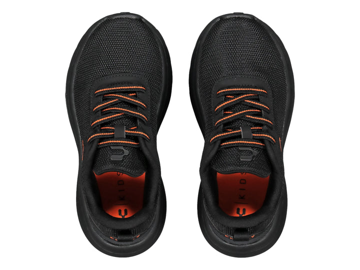 Tenis deportivos Charly color negro con detalles en naranja y suela robusta.