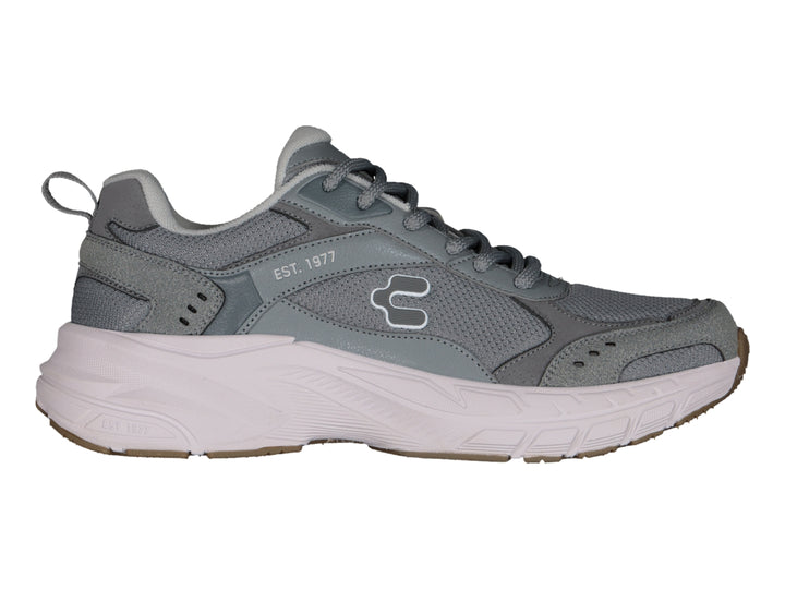 Tenis deportivos Charly color gris con suela blanca y detalles en marrón.