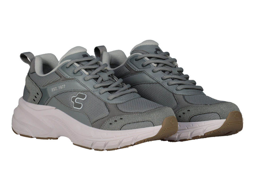 Tenis deportivos Charly color gris con suela blanca y detalles en marrón.