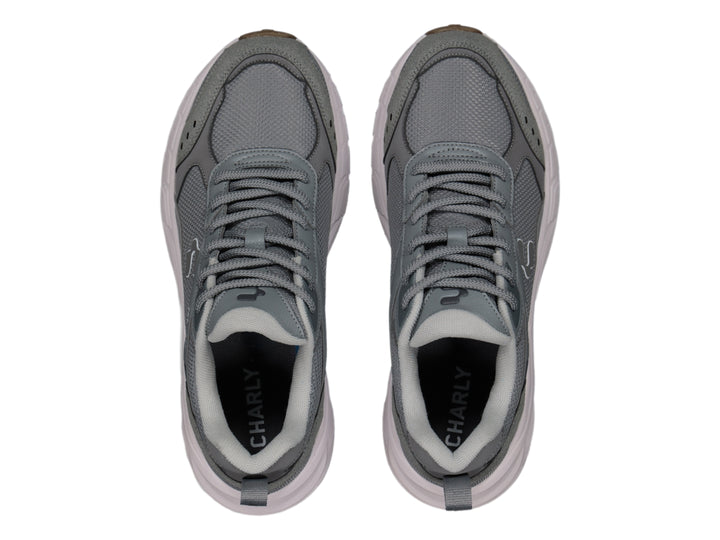Tenis deportivos Charly color gris con suela blanca y detalles en marrón.