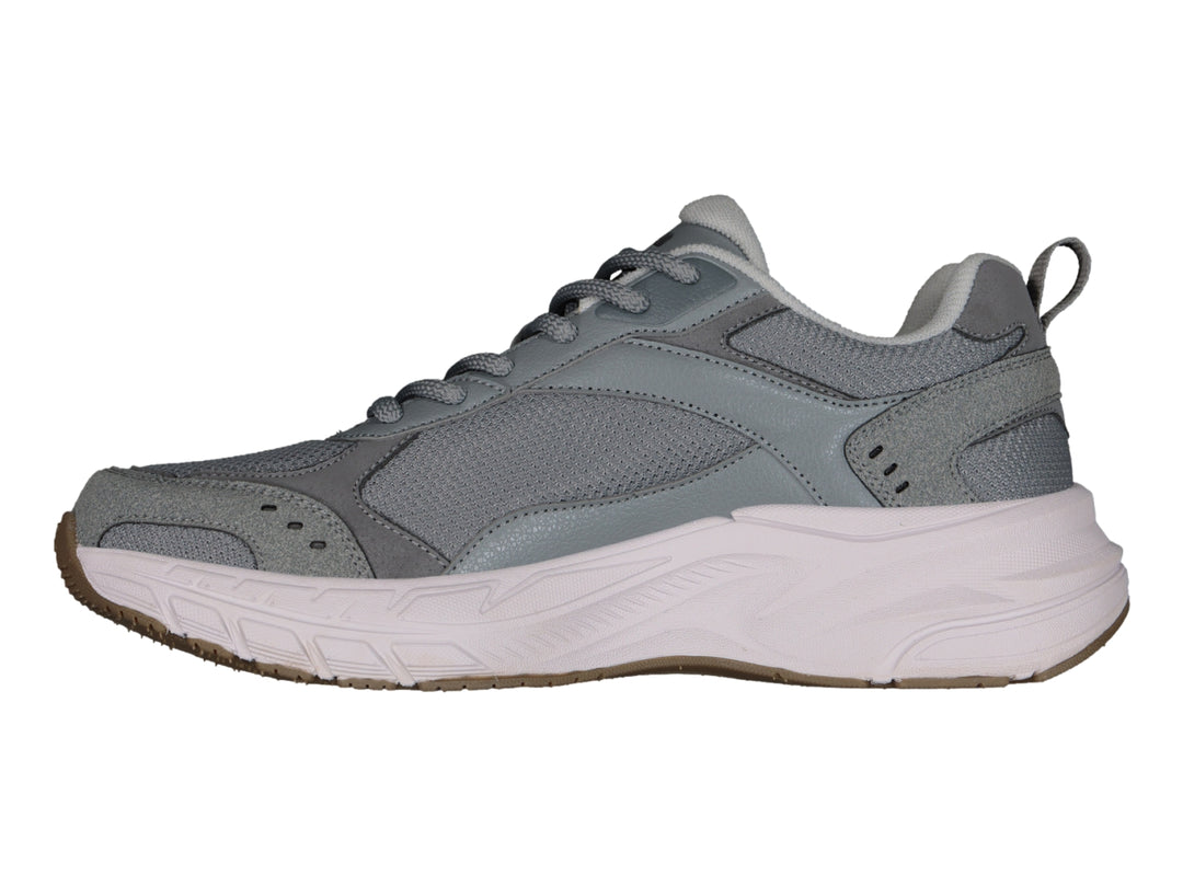 Tenis deportivos Charly color gris con suela blanca y detalles en marrón.
