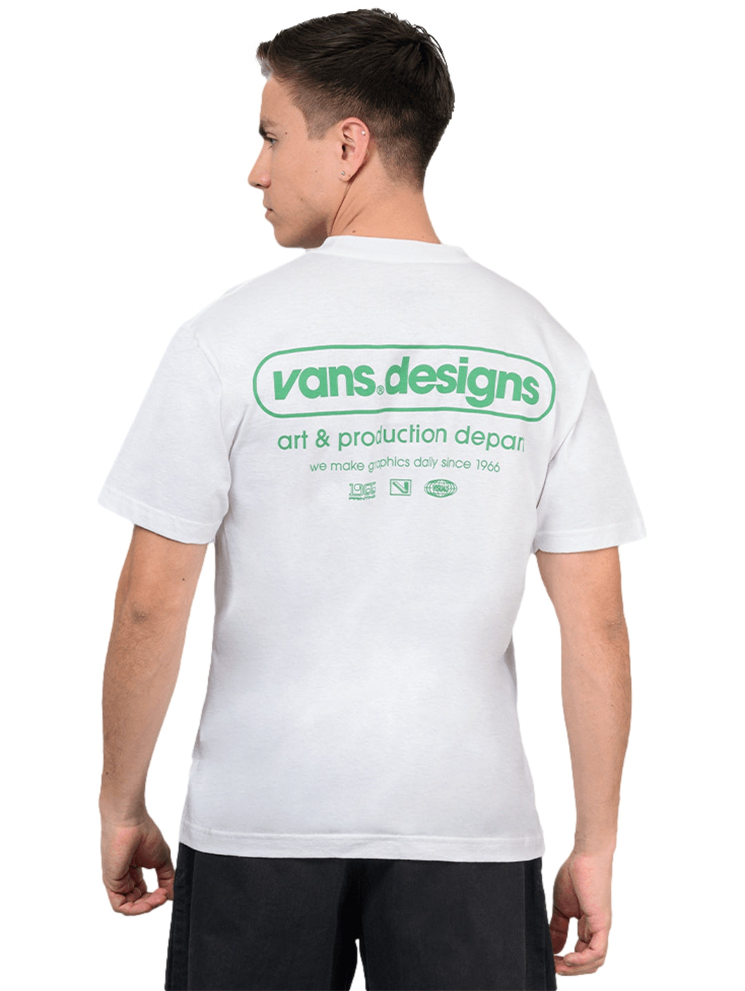 Hombre vistiendo una camiseta blanca de manga corta con un pequeño gráfico verde en el pecho.