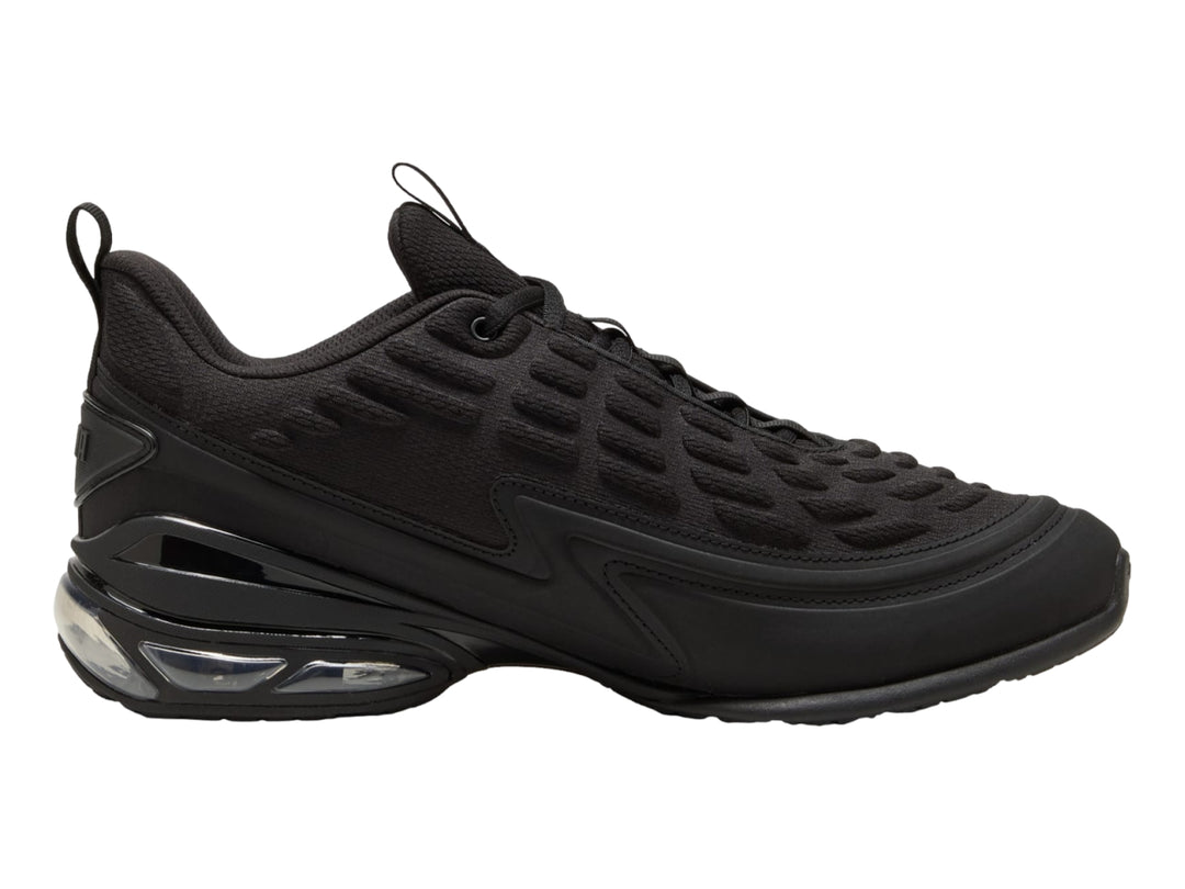 Tenis PUMA color negro con detalles en gris oscuro y cámara de aire visible en el talón.